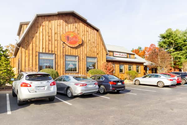 rustic restaurant exterior with wooden facade and parking area in a casual dining setting