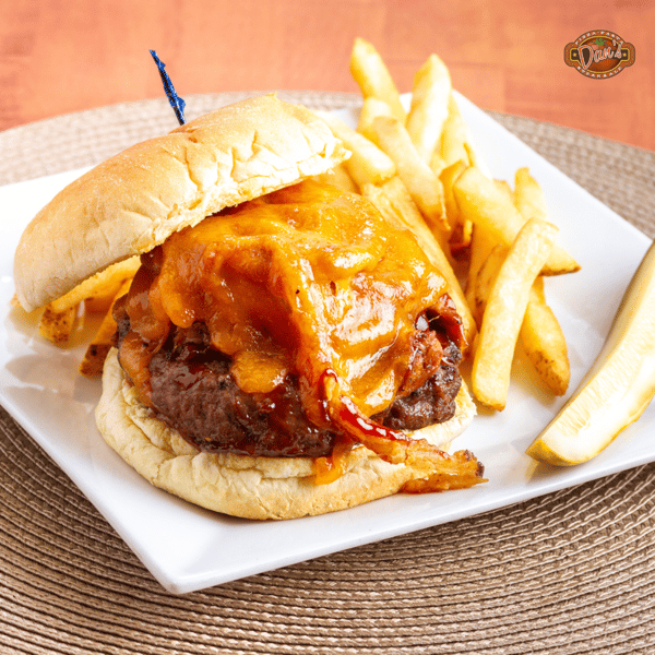 cheeseburger topped with melted cheddar served with crispy fries on a plate