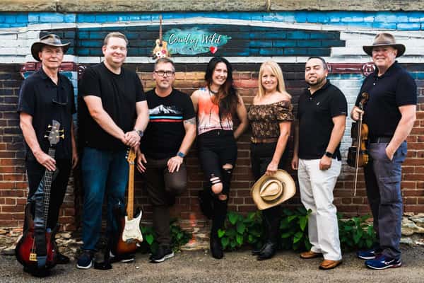 group of staff posing together outdoors at a restaurant with a welcoming, casual atmosphere