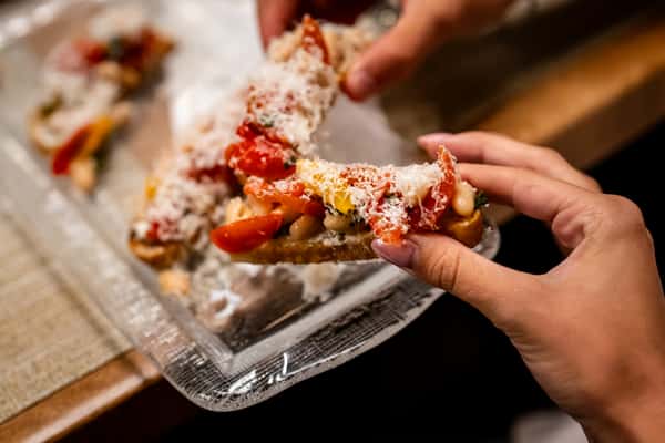 Hand holding bruschetta