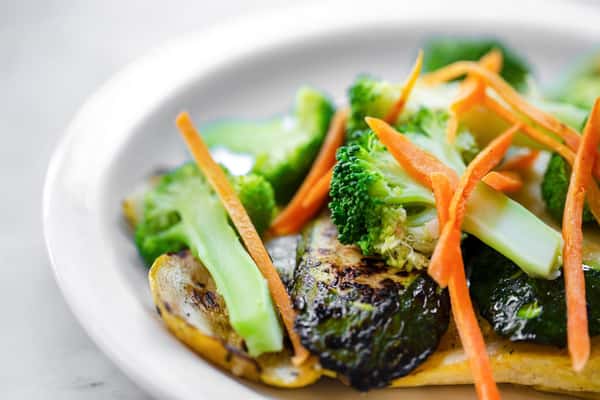 Plate of broccoli, brussel sprouts, and sliced carrots