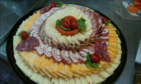 A decorated tray of cheese and meats.