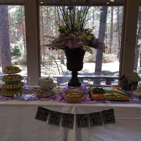 An interior buffet decorated in purple and white, with several catering trays