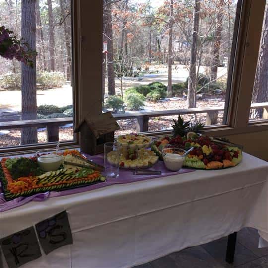 An interior buffet decorated in purple and white, with several catering trays