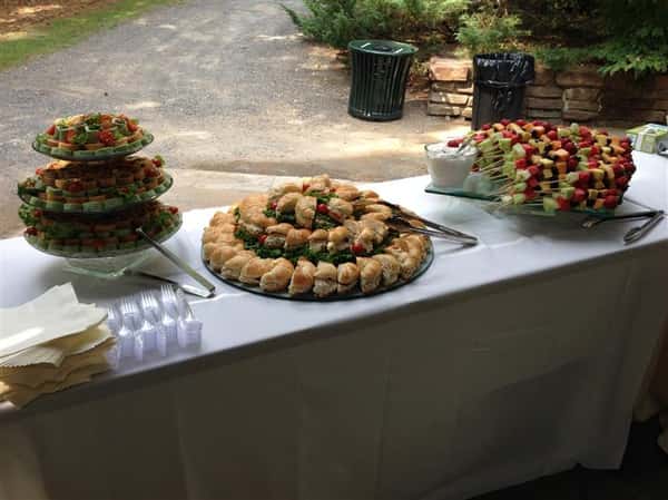 An outdoor buffet with several catering trays