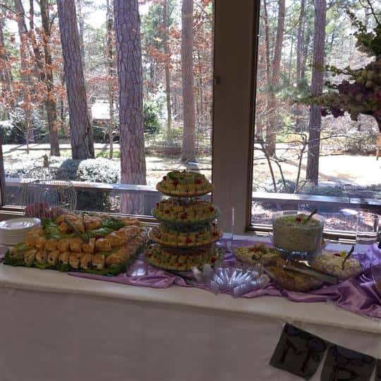 An interior buffet decorated in purple and white, with several catering trays