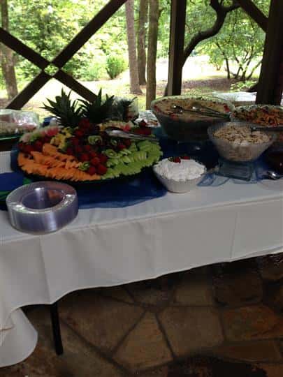 A buffet decorated in blue and white having several catering trays on it