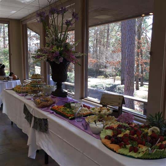 An interior buffet decorated in purple and white, with several catering trays