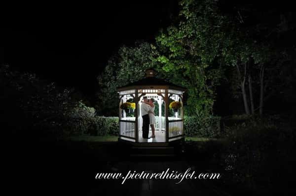 couple kissing in the outdoor gazebo at night time