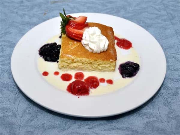 a piece of pound cake with strawberries and whipped cream on top