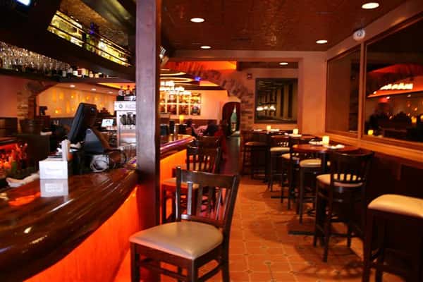 a view of the bar with barstools and side tables with bar stools