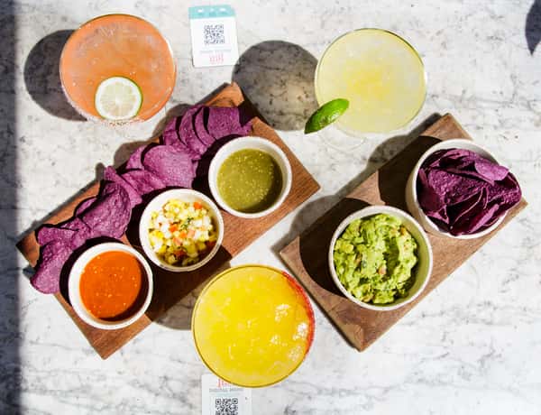 House-made guacamole, purple tortilla chips, fresh salsa trio, and handcrafted margaritas served for sharing.