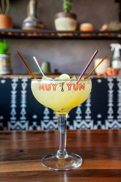 Oversized signature margarita served in a branded cocktail glass, showcasing a vibrant Mexican-inspired drink experience.