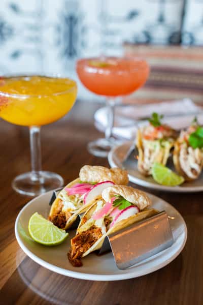 Street tacos and handcrafted cocktails served alongside vibrant Mexican appetizers in a contemporary dining setting.