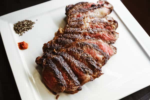 Savor perfection with a high-quality Wagyu steak, expertly cooked to your preference, elegantly presented on a pristine white plate.