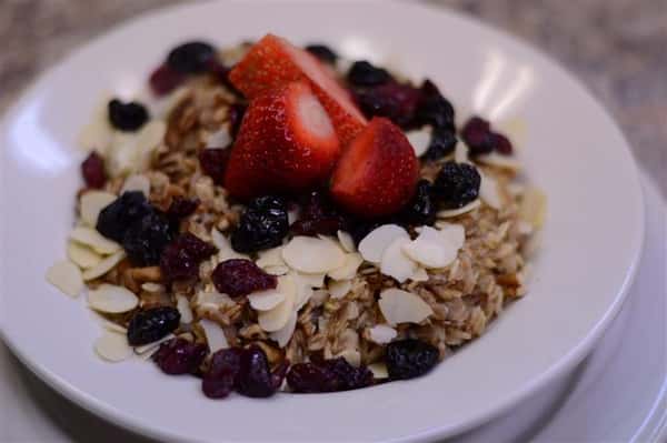 Strawberries, cranberries, sliced almonds and granola in dish