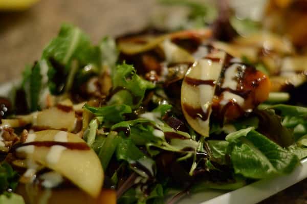 Salad with apple slices, tomatoes, balsamic drizzle