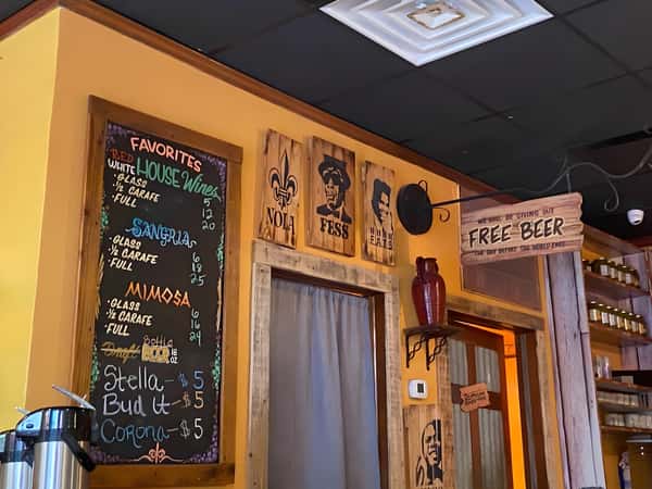 A shot of the restaurant's decor, showing a chalkboard menu, wooden wall panels, and a glimpse of the kitchen or service area.