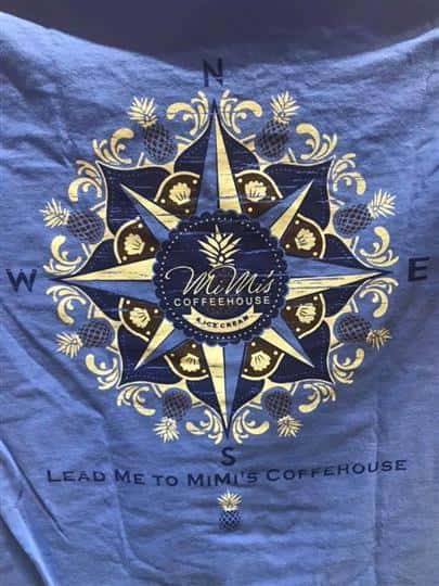 the mimi's coffeehouse and ice cream logo in the middle of a compass with "Lead me to mimi's coffeehouse" printed under it on a t-shirt