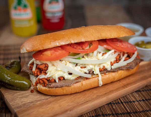 Traditional Mexican torta filled with grilled steak, crumbled chorizo, shredded lettuce, fresh tomatoes, onions, and melted cheese on a soft telera roll — a popular choice in taquerías and Mexican delis.