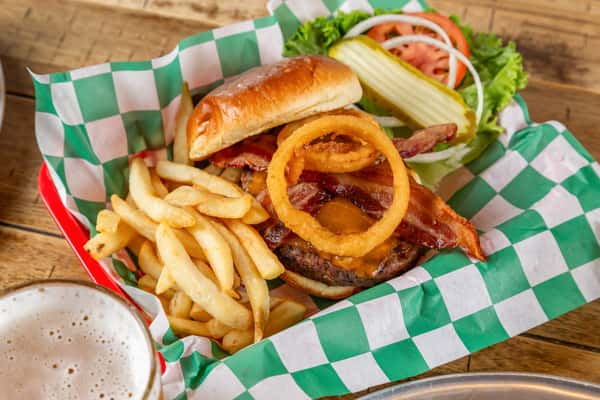 Burger topped with bacon, cheddar, and onion rings, served with fries, pickle spear, and fresh lettuce, tomato, and onion.