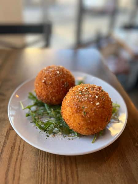 white plate on a table loaded with 2 balls of food