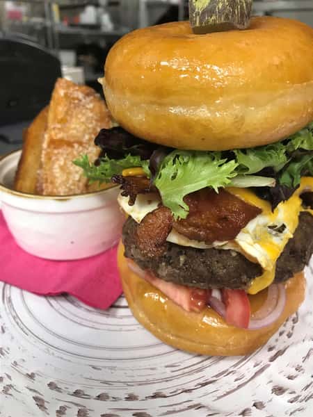 Donut Burger: 1/2 pound local beef, bacon, American cheese, lettuce, tomato, onion, fried egg, finished with maple aioli on a glazed donut