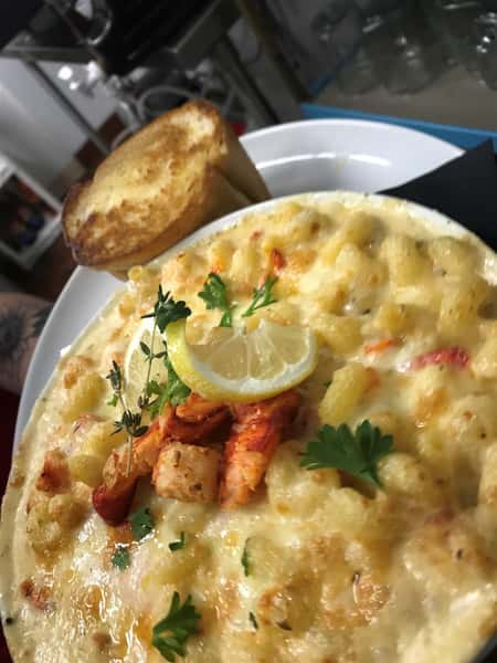 Lobsterlicouis Mac: Pasta tossed in a homemade white cheddar, Havarti & gouda cheese sauce stuffed with mounds of real lobster & finished with lemon zest & fresh thyme