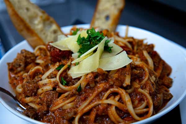 linguine tossed in bolonese sauce with garlic bread
