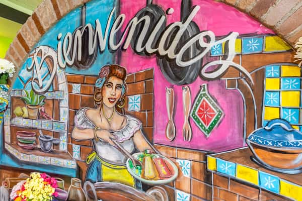 Vibrant Bienvenidos mural featuring colorful Mexican artwork inside the restaurant