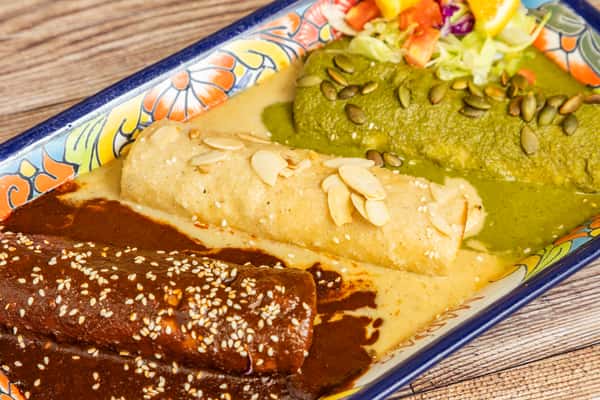 Mexican mole combination plate served with guacamole, rice, beans, and fresh garnish