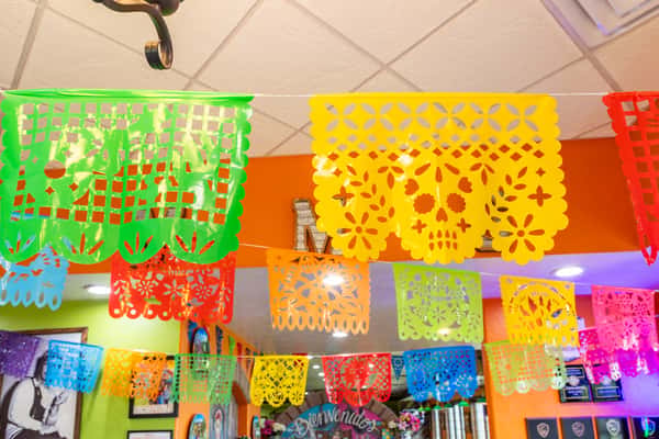 Colorful papel picado decorations hanging from the ceiling inside Maria's Mexican Grill