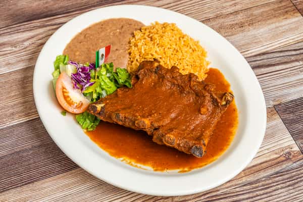 Mexican-style ribs in red sauce served with rice, refried beans, and fresh salad
