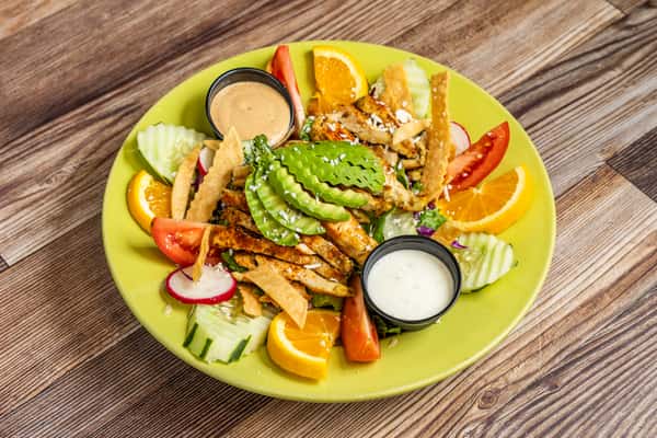 Fresh chicken salad with sliced avocado, tomatoes, vegetables, and creamy dressing