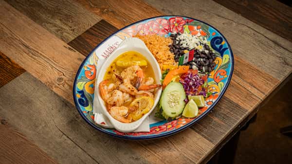 Shrimp in creamy sauce with cucumber, black beans and fresh vegetables on a Talavera platter