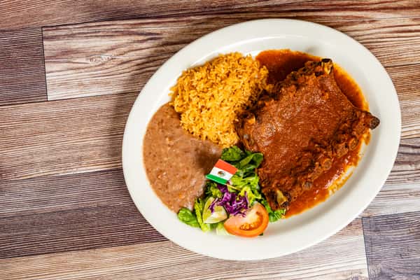 Saucy ribs served with Mexican rice, refried beans, lettuce, and tomato