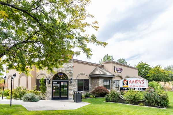 Main entrance of Maria's Mexican Grill surrounded by trees and landscaping