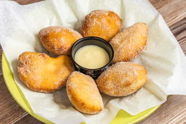 Golden Mexican-style pastry bites served around a creamy dipping sauce