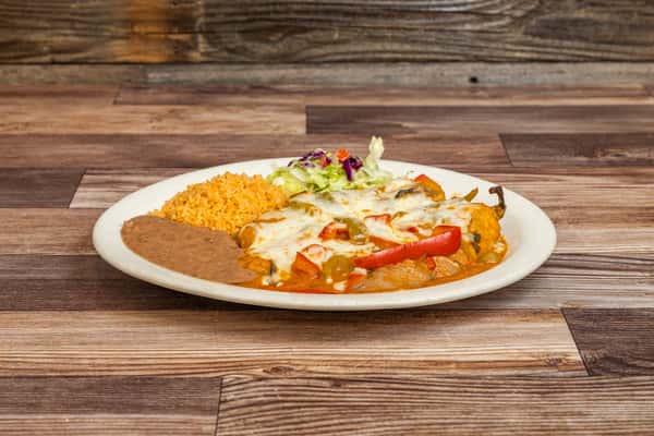 Chile relleno covered with melted cheese and served with Mexican rice and beans