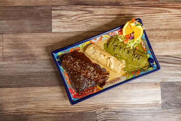 Mexican mole dish served with refried beans, guacamole, and fresh garnish