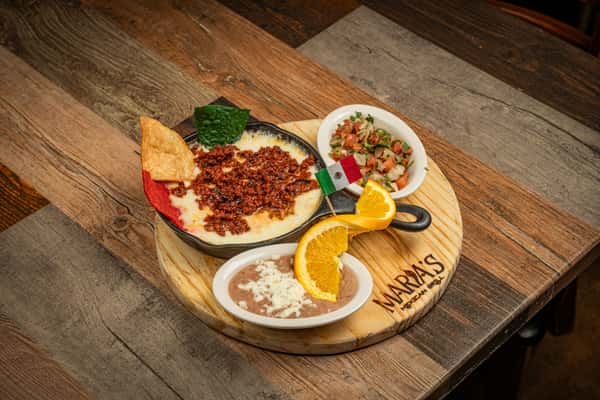 Wooden board with chips, salsas, beans and orange slices at Maria's Mexican Grill