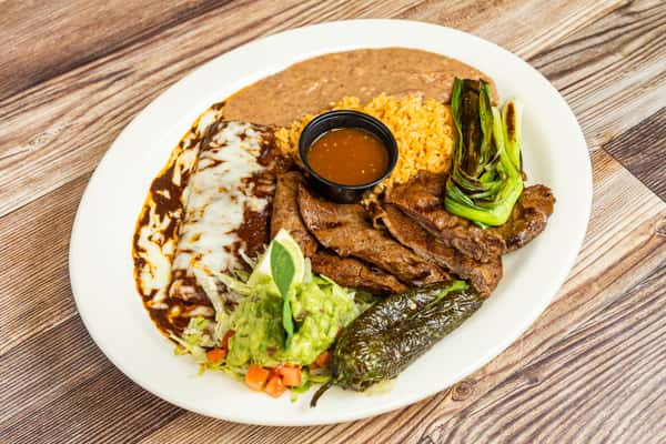 Tampiqueña steak plate served with rice, beans, guacamole, and traditional Mexican sides