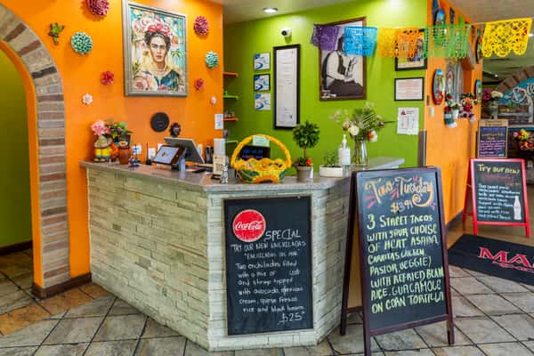 Colorful host counter with handwritten menu boards and Mexican décor