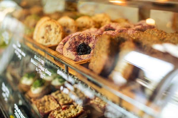 Display case of assorted baked goods featuring blueberry hibiscus sugar cookies labeled with a price tag of $4.75.