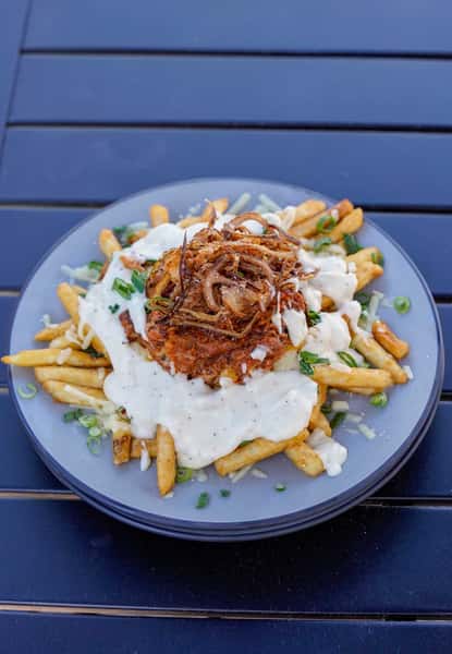 Loaded Cajun fries topped with crispy fried seafood, creamy white sauce, melted cheese, green onions, and crispy onion strings