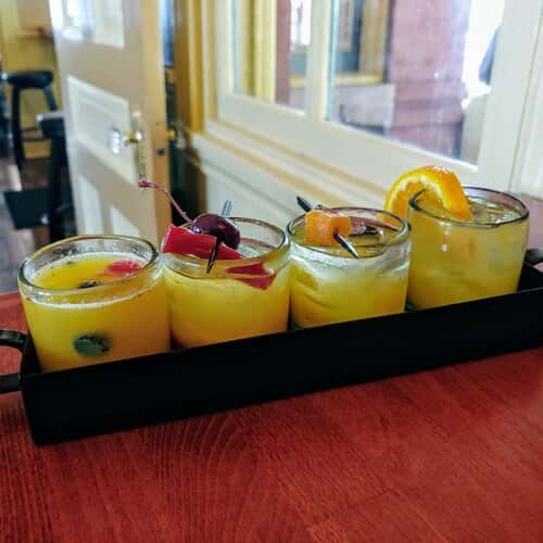 Four yellow alcoholic drinks.