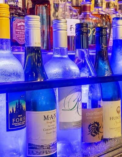 Illuminated wine display showcasing chilled bottles of white wine and sparkling selections at Water Oak Seafood and Steak Restaurant in Safety Harbor, FL.