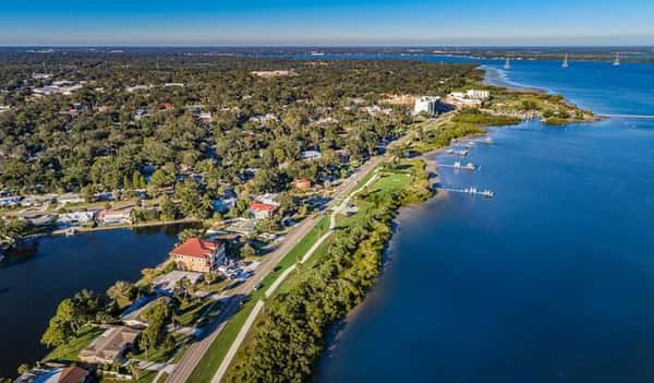 Aerial view of Safety Harbor's scenic waterfront with marinas, lush greenery, and charming coastal neighborhoods along Tampa Bay.