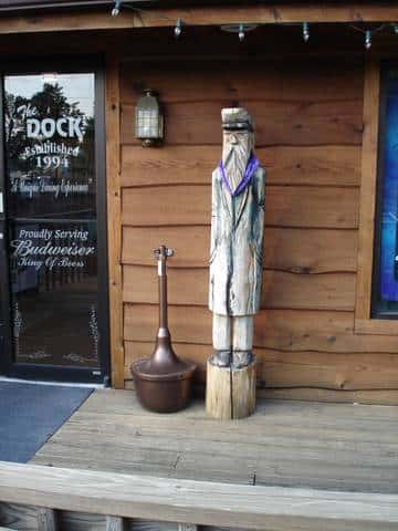 Statue of a sailor man on a wooden stump