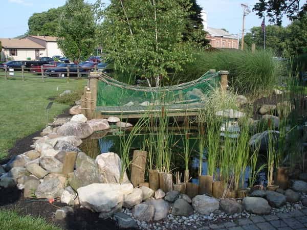 Bridge over a pond with parking lot in the background